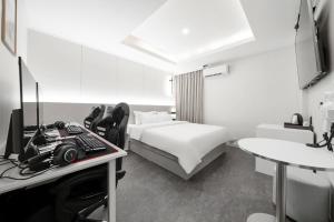 a bedroom with a bed and a desk with a camera at No25 Hotel Songnae Station in Bucheon