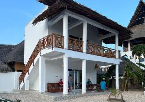 a white building with a balcony on top of it at Diacarisma Boutique Resort Nungwi in Nungwi