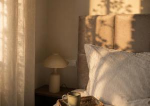 a bed with a pillow and a cup and a lamp at Erftlodges L2 in Bad Münstereifel