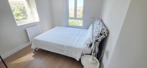 a small bedroom with a bed and a window at Sand House Gorliz By Kima Gestión in Górliz-Elexalde