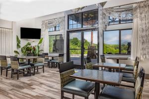 a restaurant with tables and chairs and large windows at Days Inn by Wyndham Waynesville NC in Waynesville