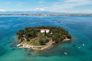 an island in the water with a building on it at Rooms Sorićev Dvor in Preko