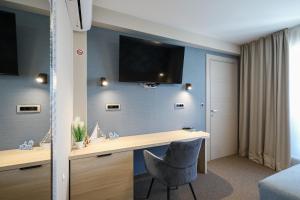 a room with a desk and a television on the wall at Rooms Sorićev Dvor in Preko