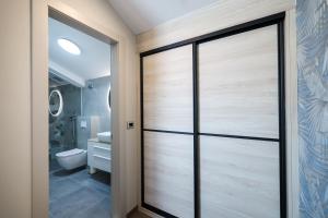 a pivot door in a bathroom with a toilet at Rooms Sorićev Dvor in Preko +48 photos