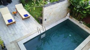 an overhead view of a swimming pool with two chairs at VILLA PAPA PUTU in Banjar +48 photos