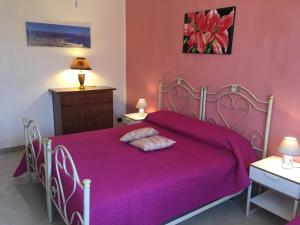 a bedroom with a purple bed with two pillows on it at B&B Villa Giacrì in Rilievo