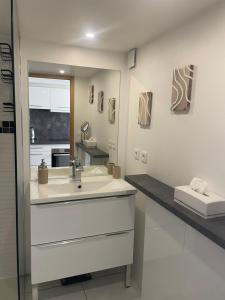 a white bathroom with a sink and a mirror at Duplex sur Marinas Cap d'Agde in Cap d'Agde +16 photos