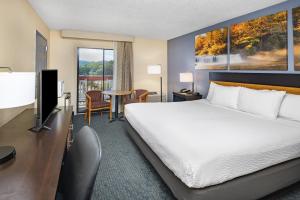 a hotel room with a bed and a television at Days Inn by Wyndham Waynesville NC in Waynesville +13 photos