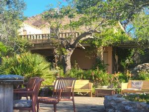 a patio with chairs and a table in a yard at Mas de Mingall in Les tres Cales