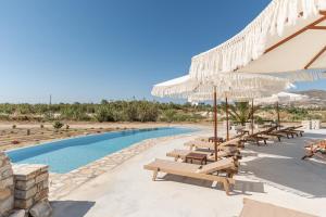 a resort with a pool with benches and umbrellas at Naxian Air in Naxos Chora