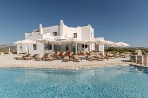 a resort with a swimming pool and chairs and umbrellas at Naxian Air in Naxos Chora