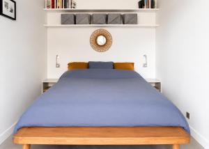 a bedroom with a blue bed with white walls at Cannes - Modern balcony flat perfect location in Cannes