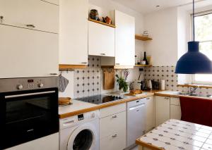 a kitchen with white cabinets and a washer at Cannes - Modern balcony flat perfect location in Cannes +9 photos