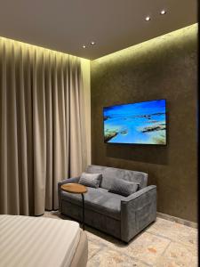 a living room with a couch and a tv on a wall at The cosy inn vlora in Vlorë +105 photos