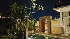a house with a swimming pool with plants in front of it at VILLA PAPA PUTU in Banjar