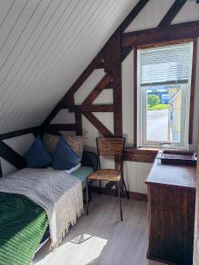 a bedroom with a bed and a chair and a window at Timber loft in Vigra