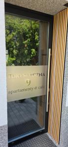 a sign in the window of a entrance to an emergency and cafe at Turystyczna 9 apartamenty & cafe in Sobótka
