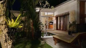 a living room with a bench and some plants at VILLA PAPA PUTU in Banjar