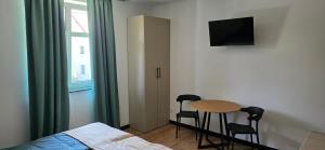 a bedroom with a table and two chairs and a bed at Turystyczna 9 apartamenty & cafe in Sobótka