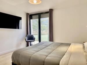 a bedroom with a bed and a television and a chair at Camping 4 étoiles - Piscine - ccbgbac in Arques