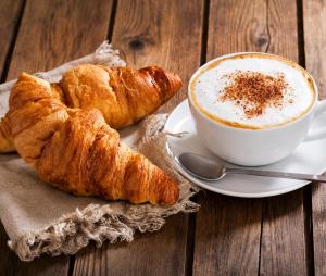 a plate of croissants and a cup of coffee at La Ruota Rooms in Casalgrande +46 photos