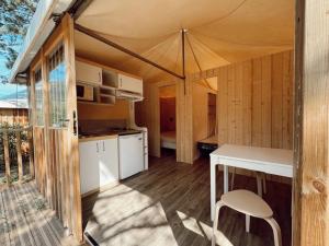 a kitchen and dining area of a tent with a table at Camping 4 étoiles - Piscine - ccbgbac in Arques