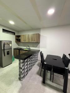 a kitchen with a table and chairs and a refrigerator at SANTYS HOUSE MELGAR apartamento amoblado 6 Huéspedes in Melgar