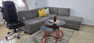 a living room with a couch and a chair and a table at Axis Luxury 1 bedroom Studio Apartment in Abuja