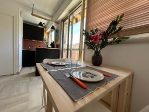 a table with two plates and a vase with flowers at Chez Raka in Hyères