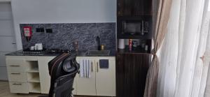 a small kitchen with a sink and a microwave at Axis Luxury 1 bedroom Studio Apartment in Abuja