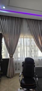 a black chair sitting in front of a window at Axis Luxury 1 bedroom Studio Apartment in Abuja