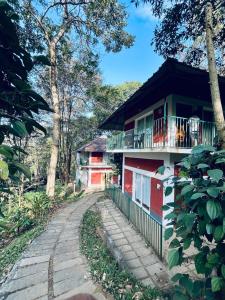 a red and white building with a balcony at Oxygen Rain Forest Resort in Kūmudi