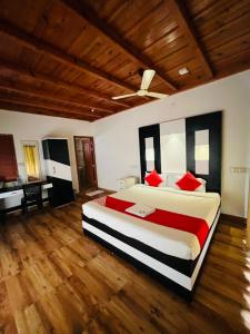 a large bedroom with a large bed with red pillows at Oxygen Rain Forest Resort in Kūmudi +15 photos