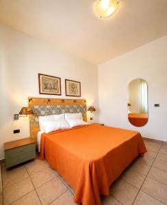 a bedroom with a bed with an orange bedspread at Riva Sweet Home in Giovinazzo +19 photos