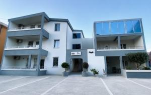 a white apartment building with a parking lot at Eki 2026 VIP in Donji Štoj