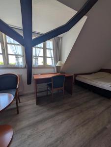 a room with a desk and a bed and windows at Westfalenkrug in Wuppertal