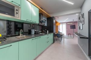 a kitchen with blue cabinets and a dining room at Social Lodge Happiness Studios in Funchal