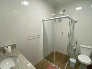 a bathroom with a toilet and a glass shower at Sítio em Guarapari in Guarapari +35 photos