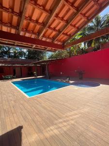 a swimming pool in a patio with a roof at Sítio em Guarapari in Guarapari