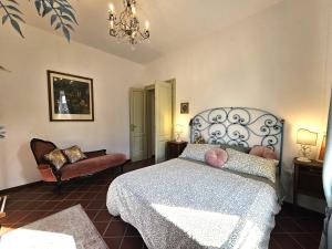 a bedroom with a bed and a chair and a chandelier at Villa Carla - vicino alla Riviera del Conero e ai Colli dell' Infinito in Ancona