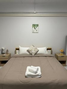 a bedroom with a bed with two towels on it at Cozy house at Central Hatyai in Sathani Khlong Rian