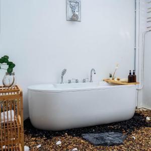a white bath tub in a white bathroom at Cozy house at Central Hatyai in Sathani Khlong Rian