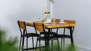 a wooden table with chairs and wine glasses on it at Cozy house at Central Hatyai in Sathani Khlong Rian