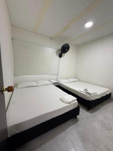 a room with two beds and a clock on the wall at SANTYS HOUSE MELGAR apartamento amoblado 6 Huéspedes in Melgar