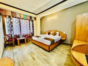 a bedroom with a bed and a table and chairs at Hotel Rana Taradevi in Shimla