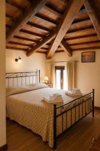 a bedroom with a large bed with wooden ceilings at La Busa alloggi e trattoria in Ponte San Nicolo