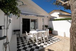 a patio with a table and chairs on a checkered floor at 30m to Beach - Mindelo Ocean House in Mindelo