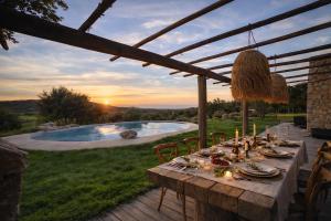 a table with plates and candles on a patio with a pool at Casa Campo Longo in Belgodère