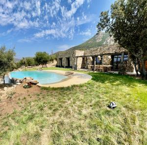 a stone building with a swimming pool in front of it at Casa Campo Longo in Belgodère +18 photos
