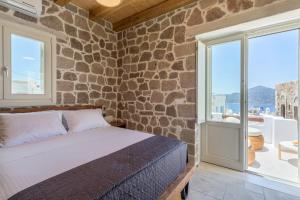 a bedroom with a bed and a stone wall at PEA Plaka Authentic Home in Plaka Milou